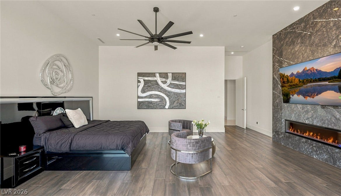 4 Chisel Crest Court, Henderson, NV 89012 Rich wood flooring runs underfoot in this master suite featuring a modern fireplace.