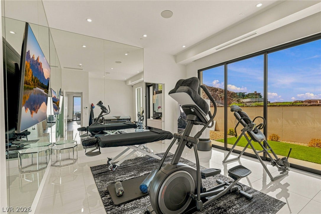 4 Chisel Crest Court, Henderson, NV 89012 Gleaming tile floors and mirrored walls elevate this modern home gym opening to the outdoors.