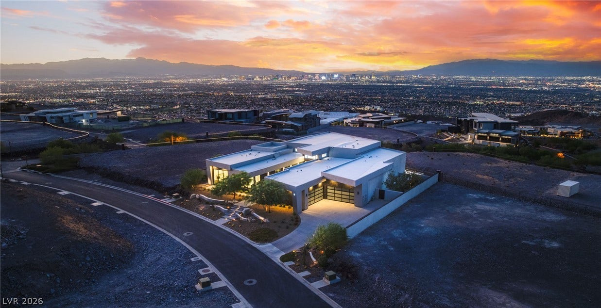 4 Chisel Crest Court, Henderson, NV 89012 Dramatic mountain and glittering city skyline vistas frame this contemporary architectural masterpiece at twilight.