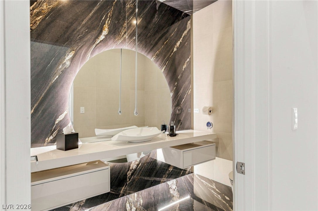 4 Chisel Crest Court, Henderson, NV 89012 Dramatic dark marble surrounds a floating vanity in this contemporary powder room.
