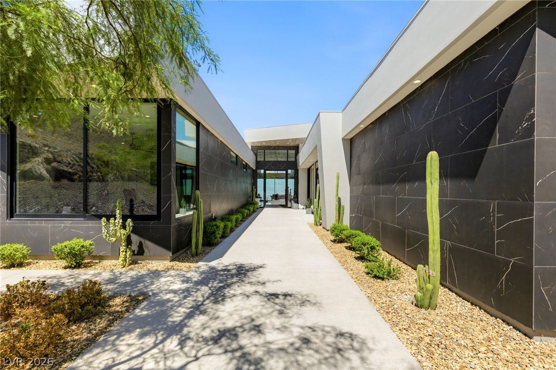 4 Chisel Crest Court, Henderson, NV 89012 Sleek architectural lines guide the eye toward a grand entryway framed by dramatic dark cladding.