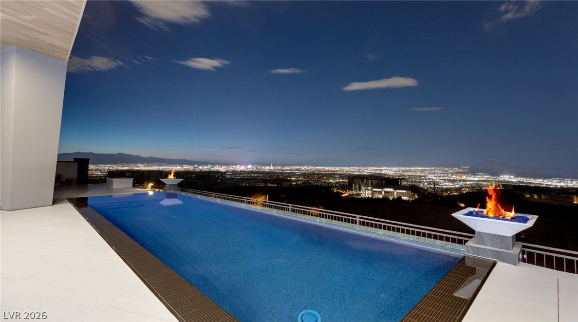 4 Chisel Crest Court, Henderson, NV 89012 An infinity pool looks out over sweeping city light views beneath the evening sky.
