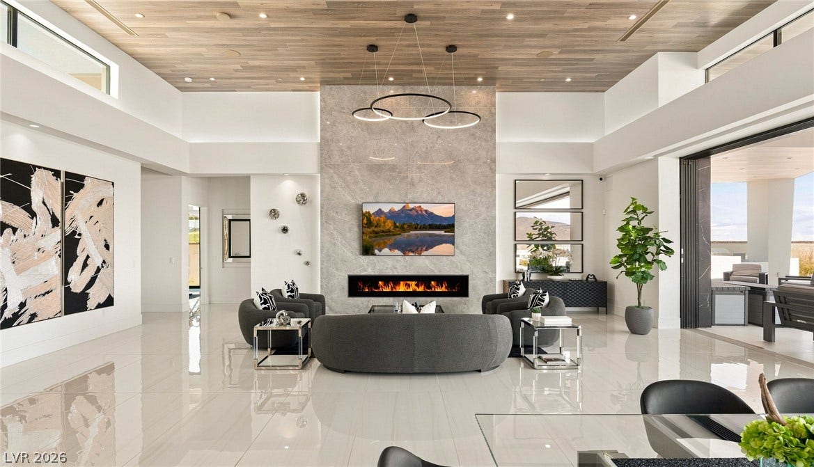 4 Chisel Crest Court, Henderson, NV 89012 Polished tile flooring and a wood-plank ceiling frame this grand fireplace room.