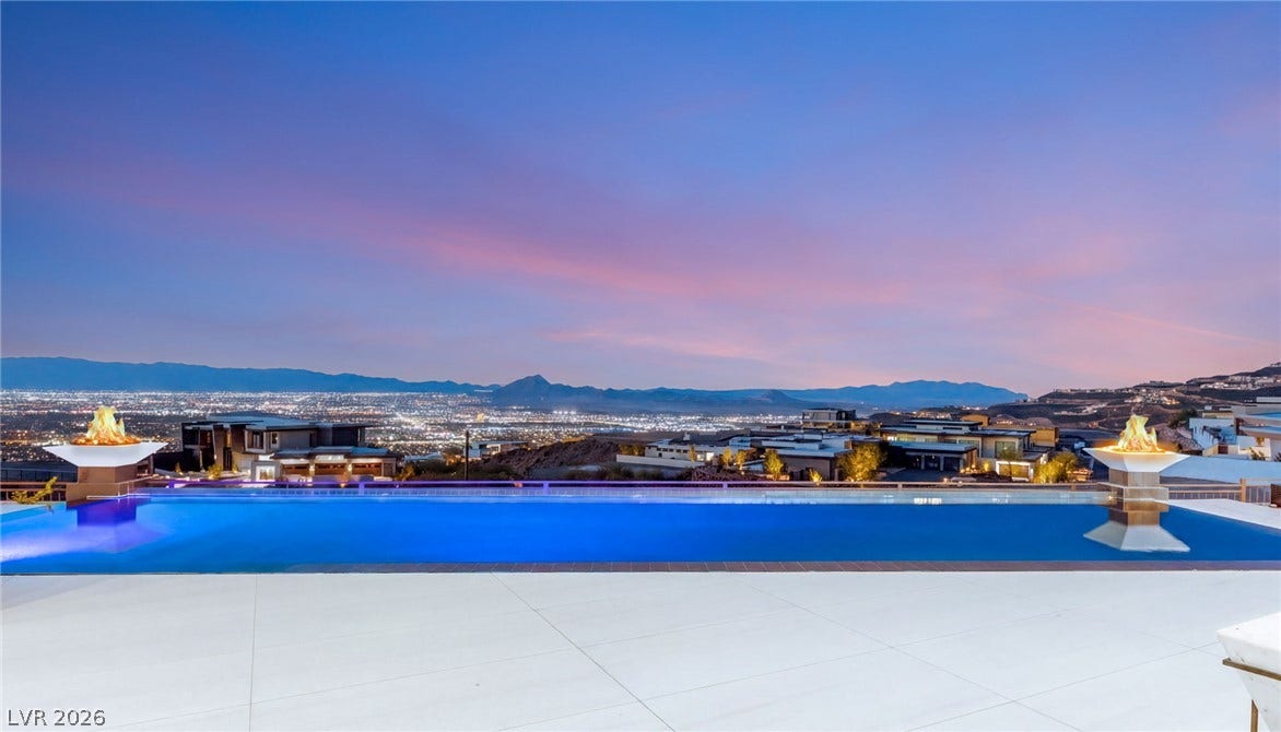 4 Chisel Crest Court, Henderson, NV 89012 An infinity pool overlooks dramatic mountain and sparkling city light views under a twilight sky.