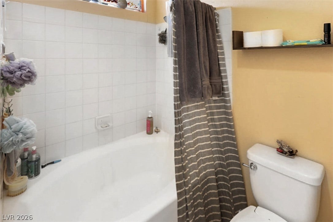 A well-maintained bathroom with a deep soaking tub and neatly tiled shower walls.