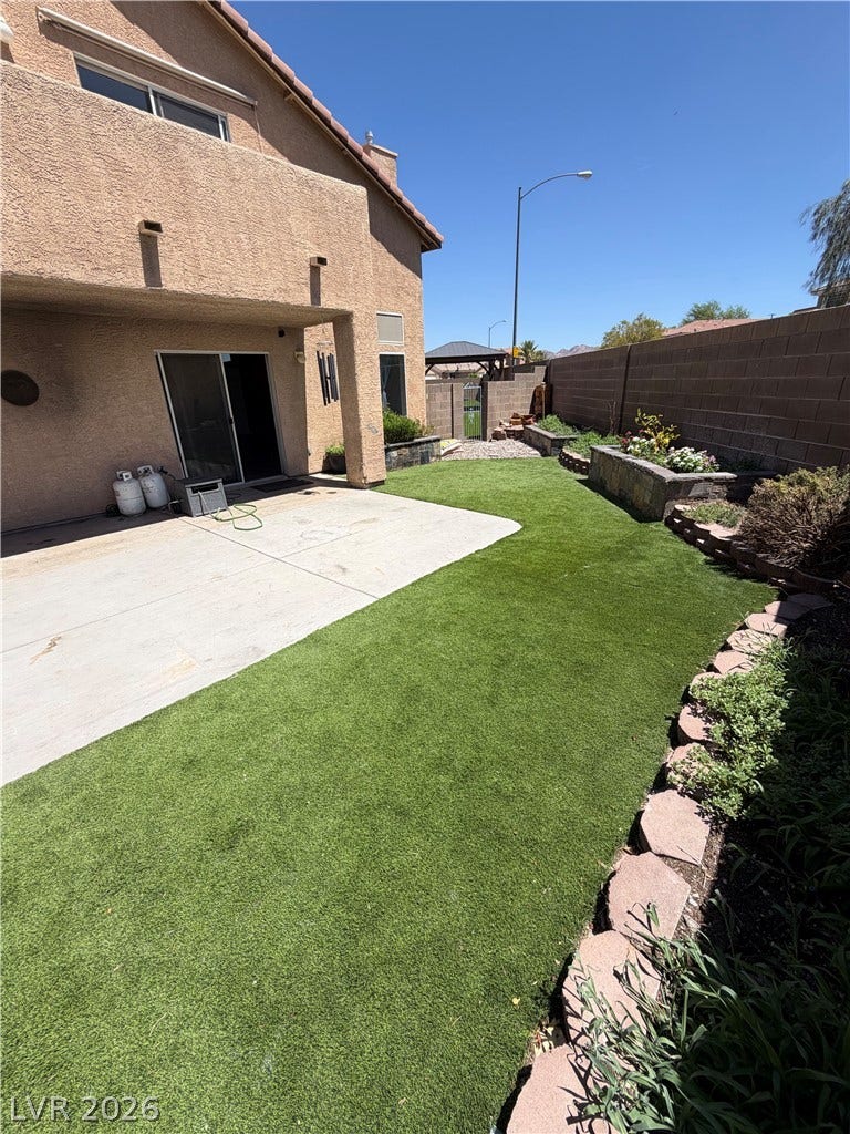 A private yard with a concrete patio and raised garden beds provides a serene outdoor escape.