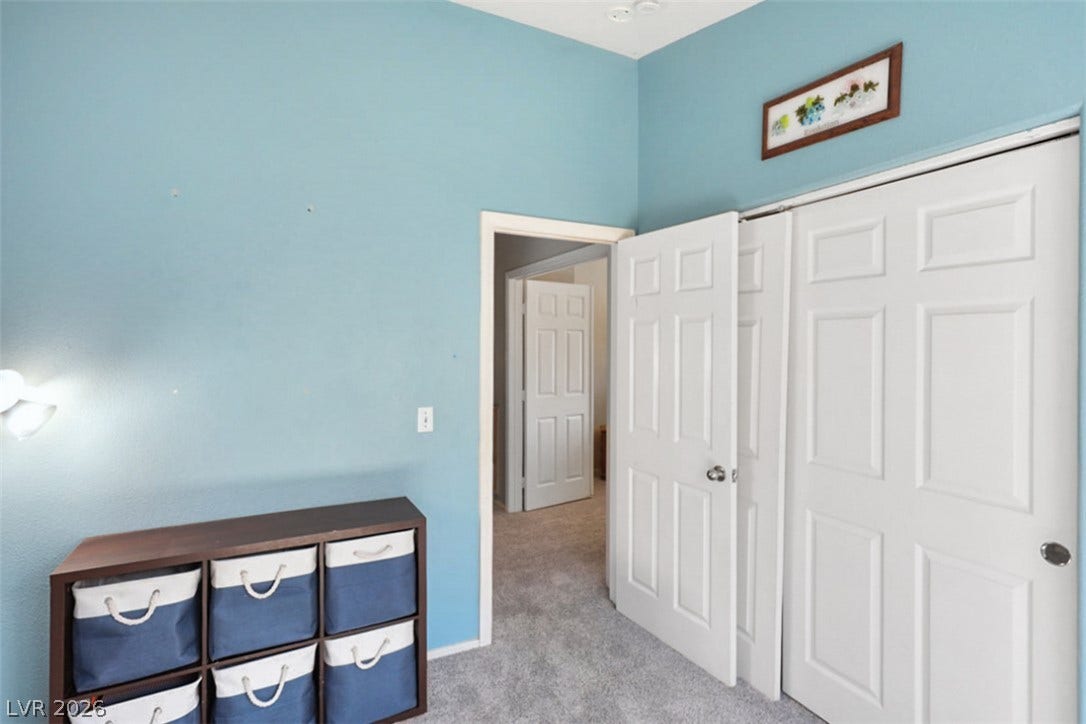 A well-maintained bedroom features plush carpeting and convenient closet space.