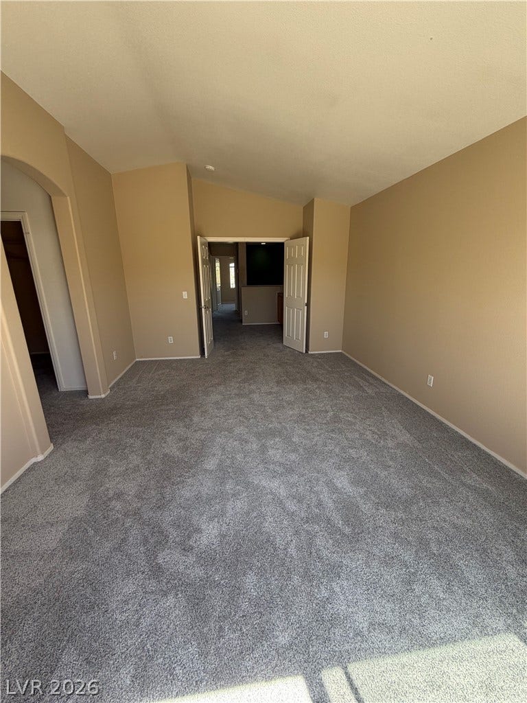 A spacious room offers new carpeting and vaulted ceilings, creating an inviting atmosphere.