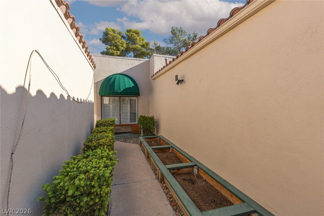 2882 Bridgepointe Drive, Las Vegas, NV 89121 Clay tile roofs accent the warm stucco exterior of this inviting courtyard pathway.