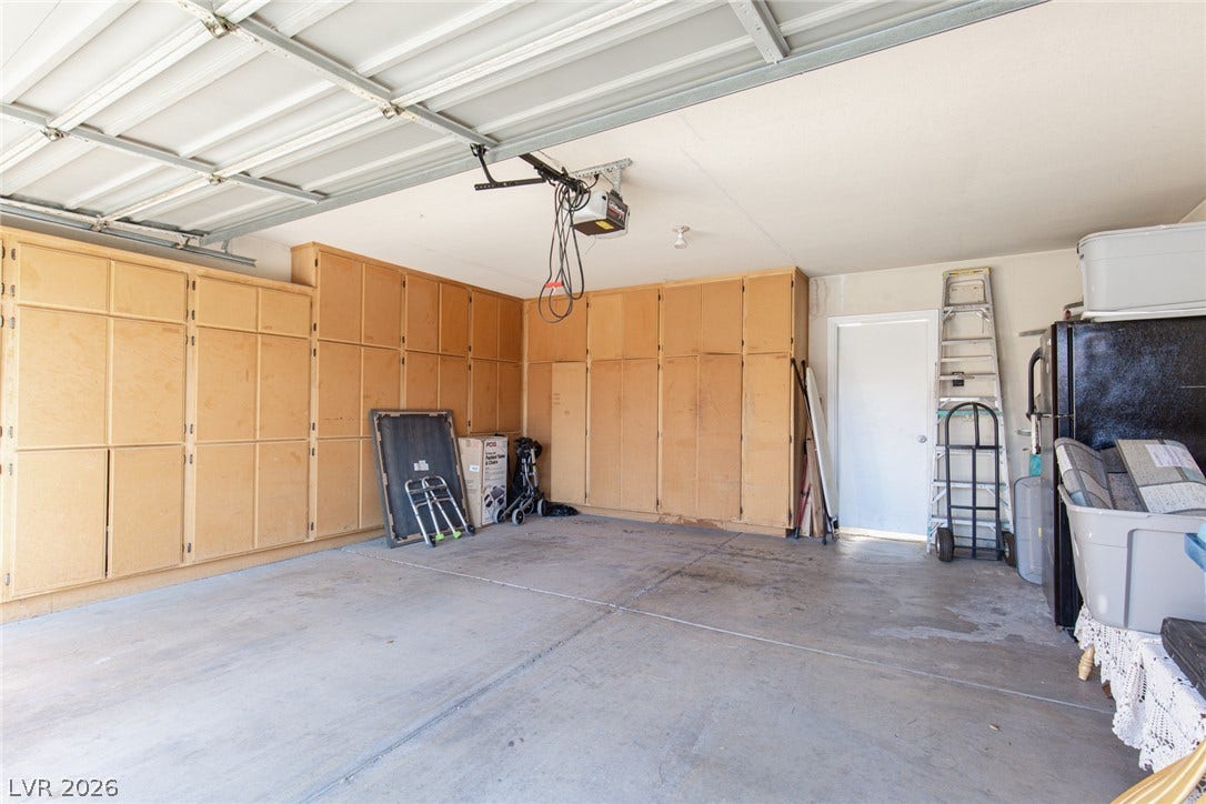 2882 Bridgepointe Drive, Las Vegas, NV 89121 An abundance of built-in wooden cabinetry lines this concrete garage space.