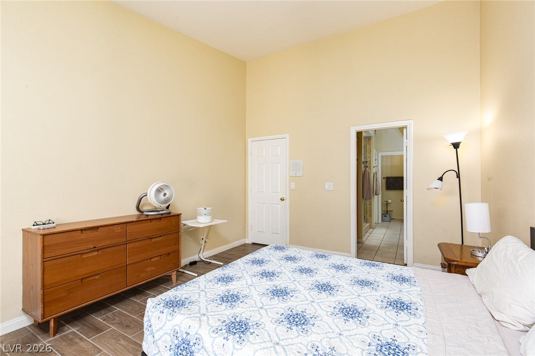 2882 Bridgepointe Drive, Las Vegas, NV 89121 High ceilings and durable tile flooring highlight this spacious primary bedroom layout.
