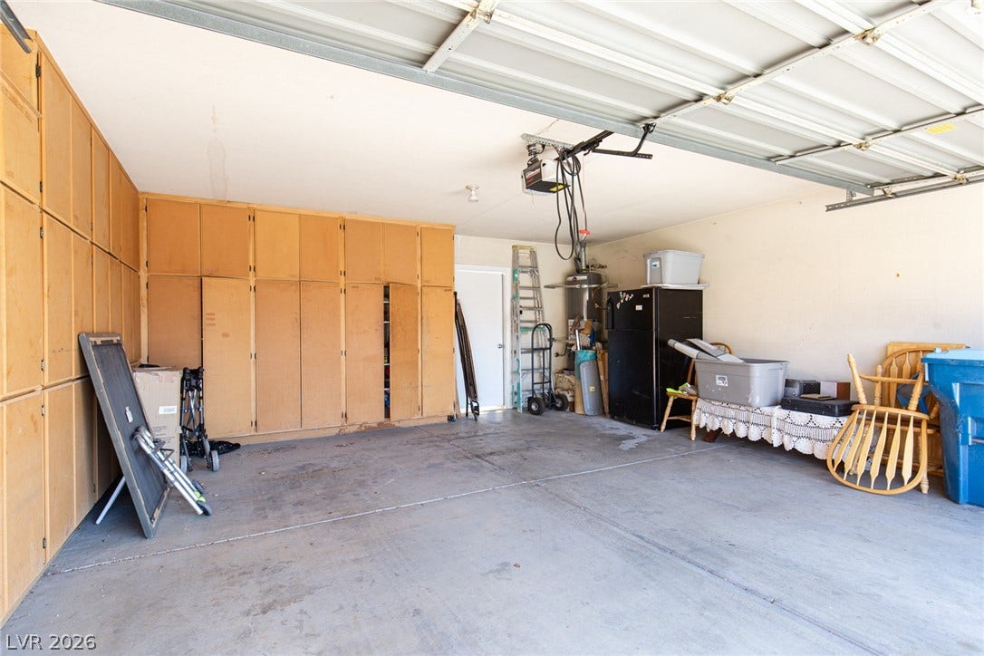 2882 Bridgepointe Drive, Las Vegas, NV 89121 Abundant built-in storage cabinets line the walls of this concrete floor garage.