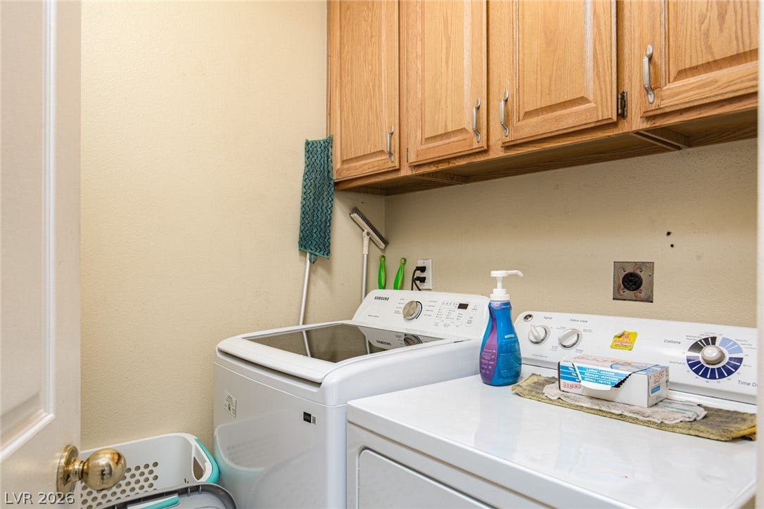 2882 Bridgepointe Drive, Las Vegas, NV 89121 Ample upper cabinets provide storage above the laundry appliances.