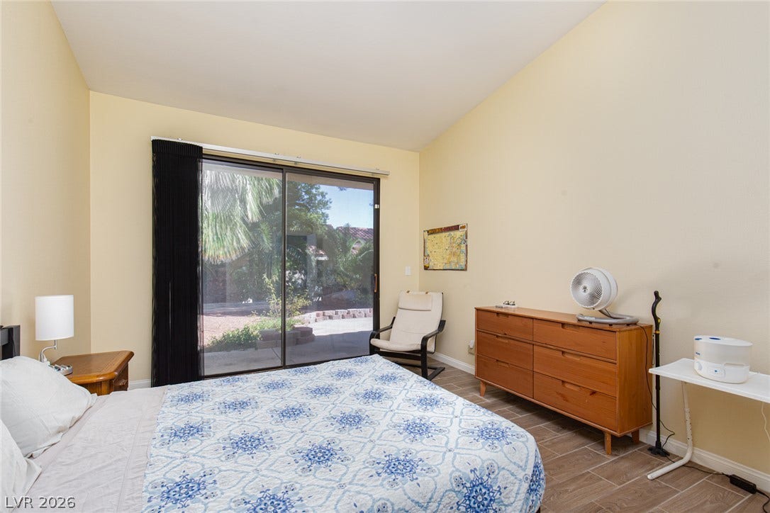 2882 Bridgepointe Drive, Las Vegas, NV 89121 Sliding glass doors open directly to the patio from this high-ceilinged bedroom.