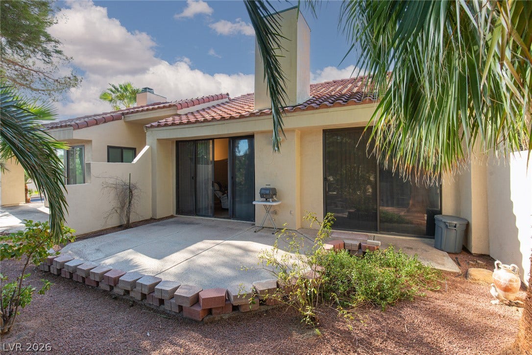 2882 Bridgepointe Drive, Las Vegas, NV 89121 Sliding glass doors open directly to a concrete patio bordered by low block walls.