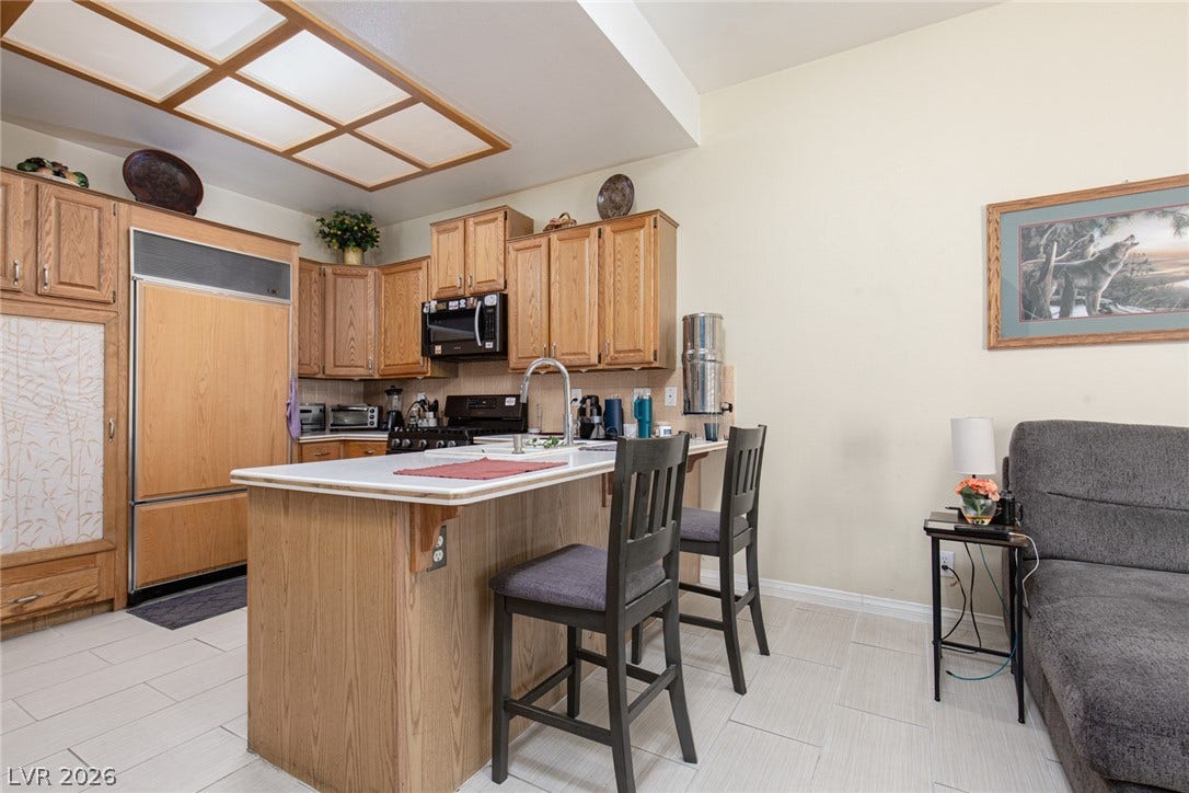 2882 Bridgepointe Drive, Las Vegas, NV 89121 Oak cabinetry and a central island anchor this functional cooking space.