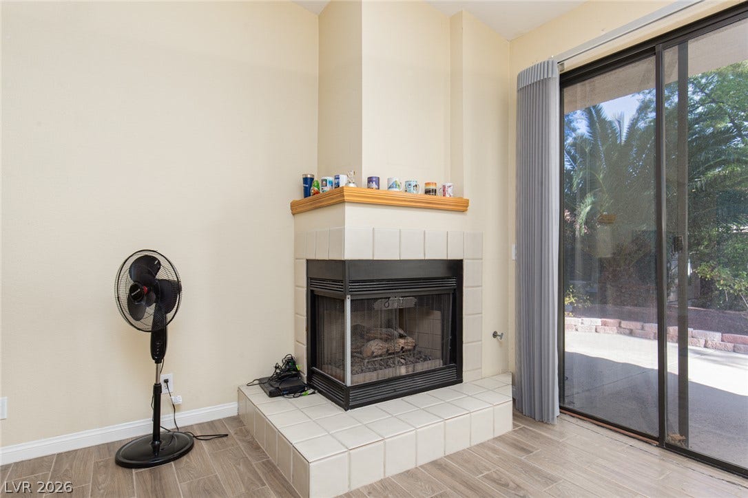 2882 Bridgepointe Drive, Las Vegas, NV 89121 Sliding glass doors open to the patio next to a tiled corner fireplace.