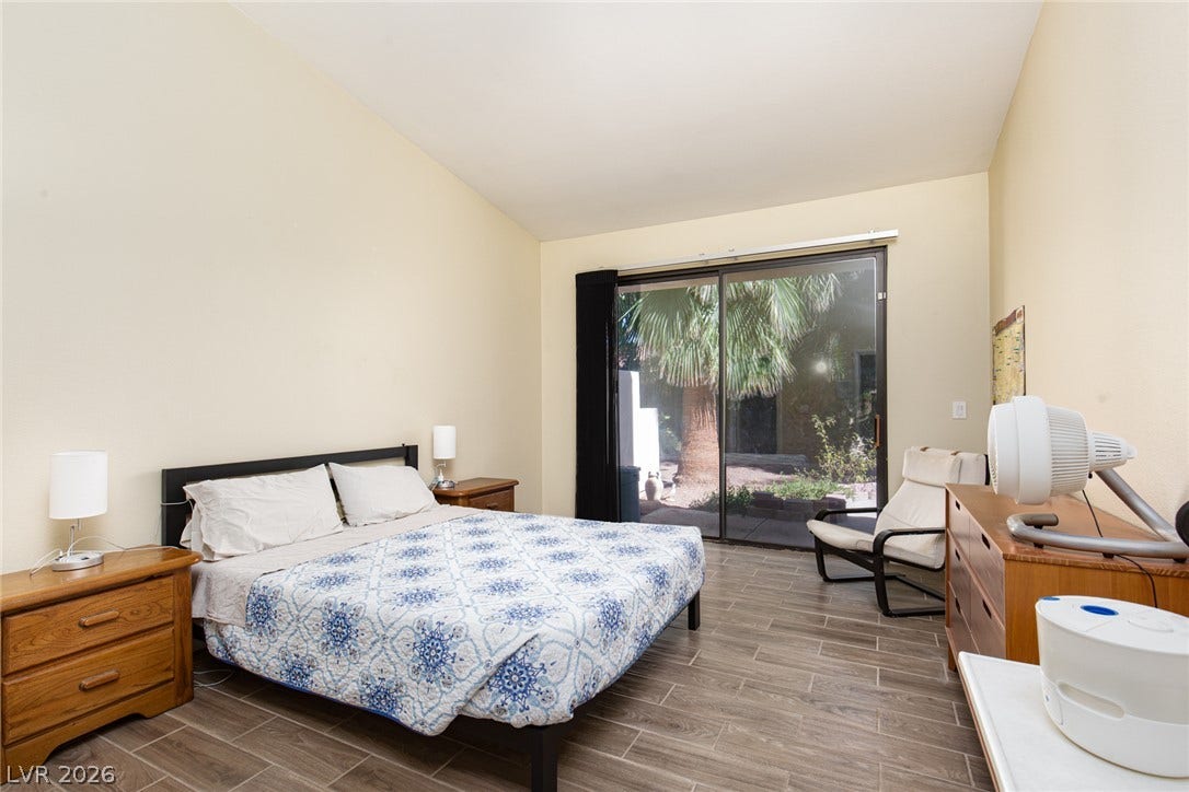 2882 Bridgepointe Drive, Las Vegas, NV 89121 Sliding glass doors open directly to the outdoors, framing views of lush palm trees.