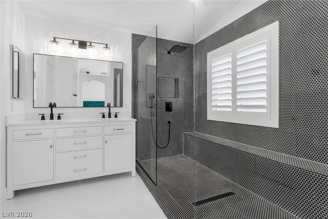 337 Teal Ridge Hills Drive, Henderson, NV 89014 Bold mosaic tile walls and a glass-enclosed shower highlight this modern bathroom design.