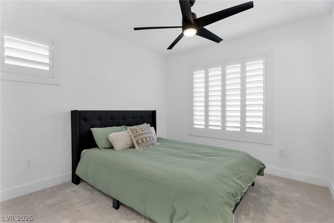 337 Teal Ridge Hills Drive, Henderson, NV 89014 Smooth plaster walls and soft carpeting frame this bedroom with classic plantation shutters.