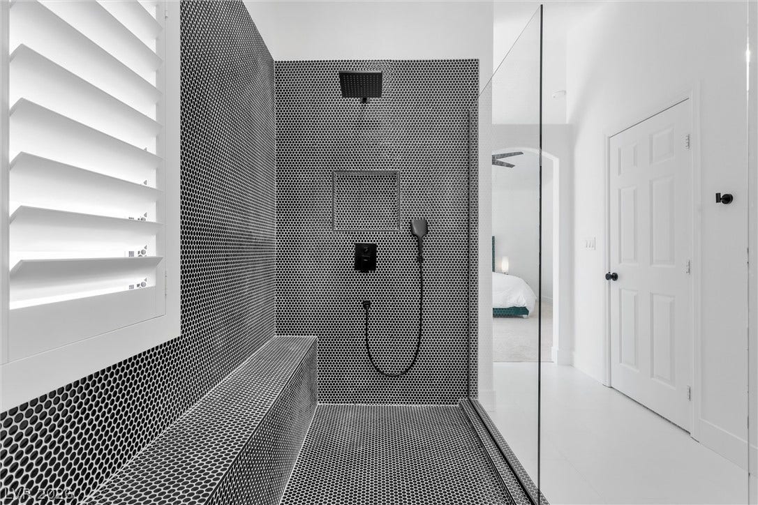 337 Teal Ridge Hills Drive, Henderson, NV 89014 Graphic penny tile and sleek glass panels define this striking modern walk-in shower design.