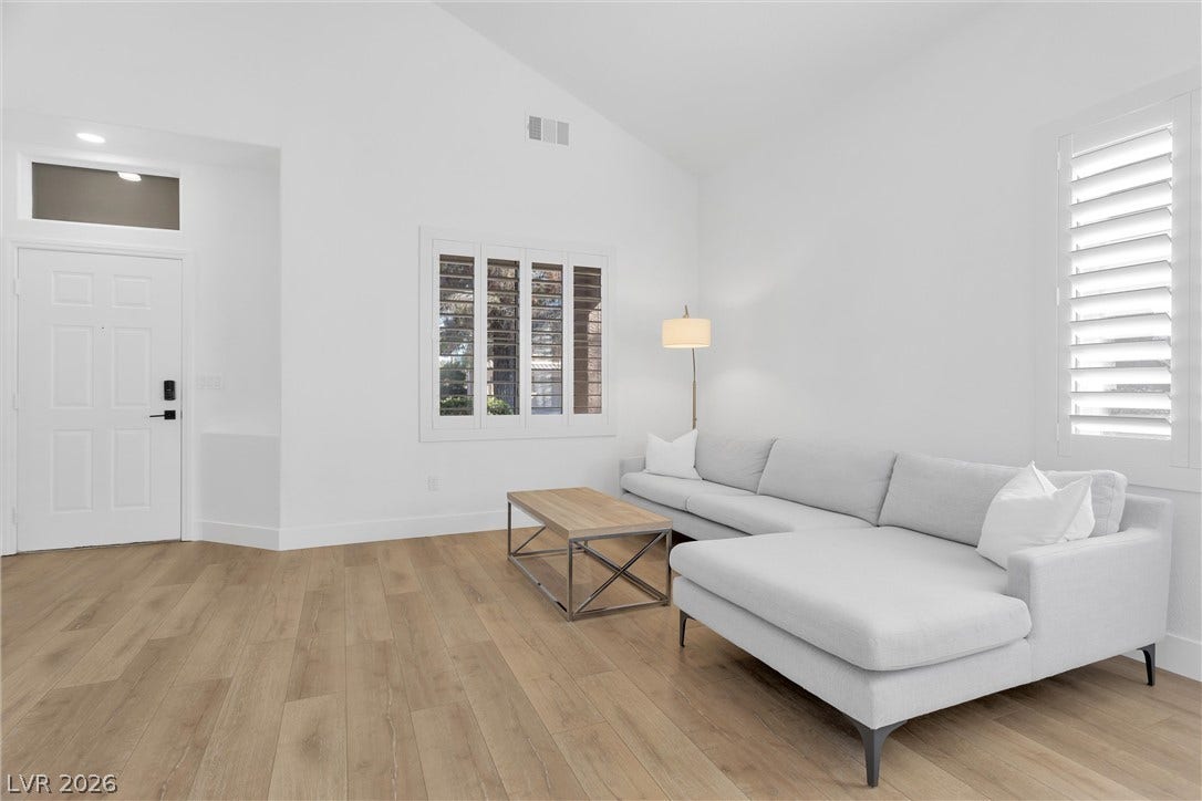 337 Teal Ridge Hills Drive, Henderson, NV 89014 Vaulted ceilings and wide-plank wood-style flooring elevate this modern living space.