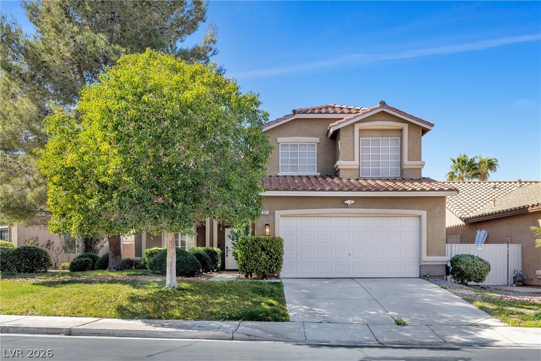 337 Teal Ridge Hills Drive, Henderson, NV 89014 A classic two-story stucco exterior displays arched architectural details and an integrated garage.