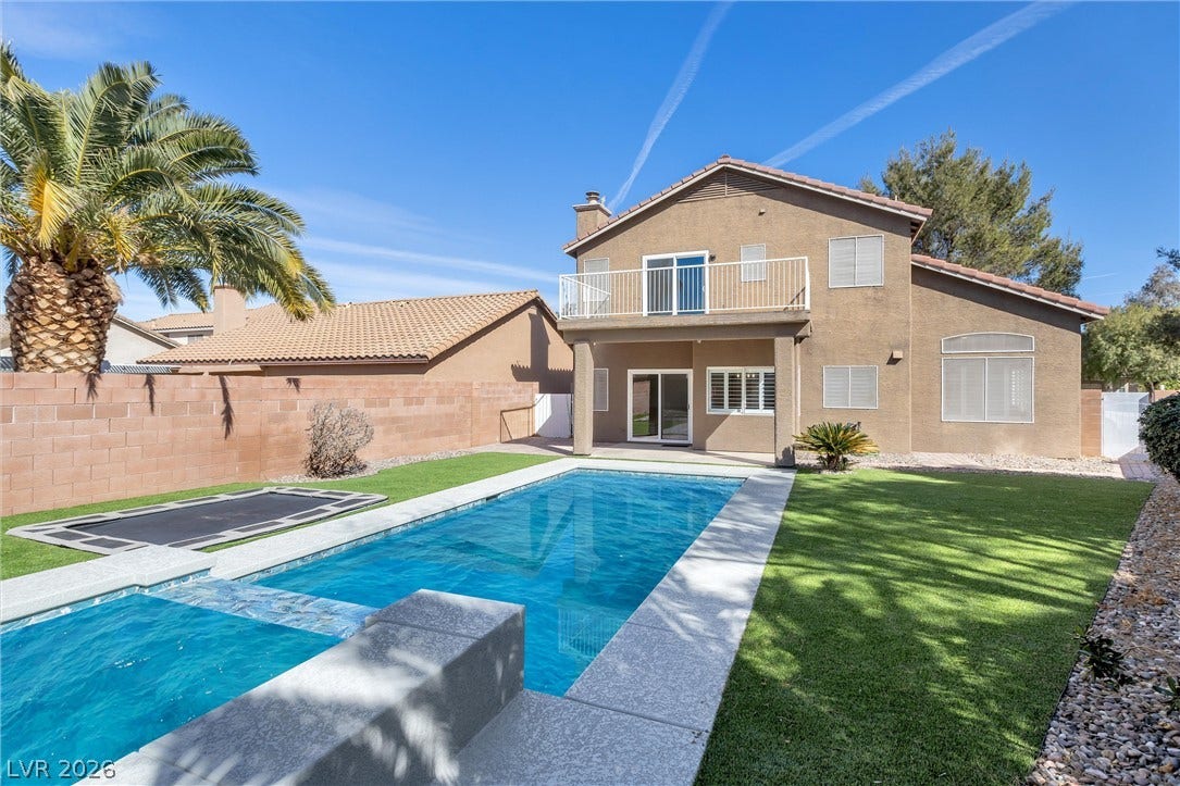 337 Teal Ridge Hills Drive, Henderson, NV 89014 An inviting backyard features a sparkling pool and spa flanked by green synthetic turf.
