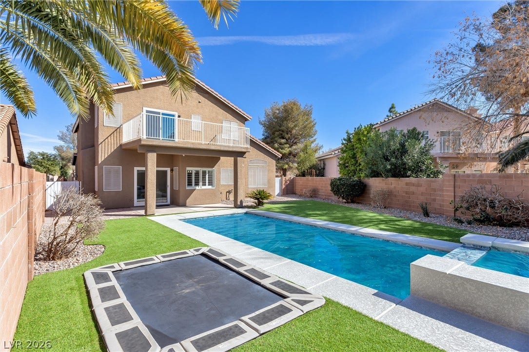 337 Teal Ridge Hills Drive, Henderson, NV 89014 Sun-drenched backyard featuring a private pool and green lawn under clear blue skies.