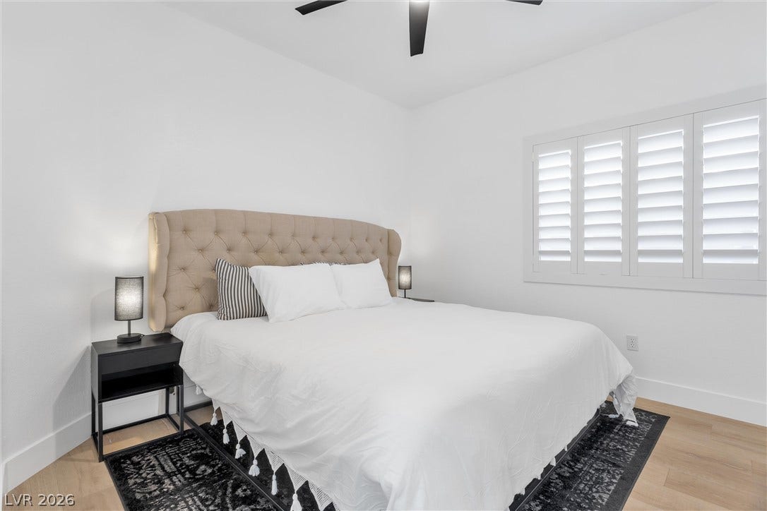 337 Teal Ridge Hills Drive, Henderson, NV 89014 Crisp white walls and warm wood flooring frame a cozy, minimalist sleeping space with custom shutters.