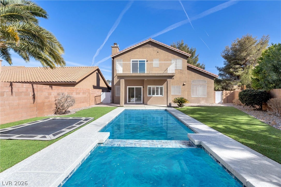 337 Teal Ridge Hills Drive, Henderson, NV 89014 An inviting backyard features a sparkling blue pool paired with a stucco two-story home.