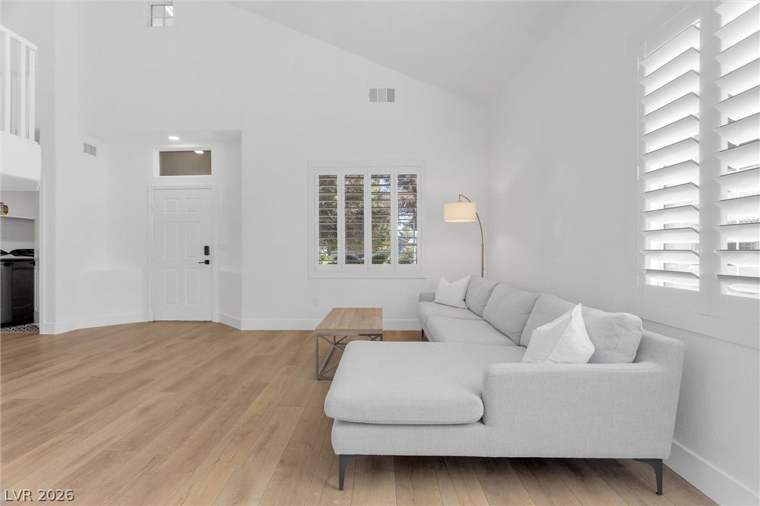 337 Teal Ridge Hills Drive, Henderson, NV 89014 High vaulted ceilings and rich wood-toned flooring anchor this inviting, naturally lit living space.
