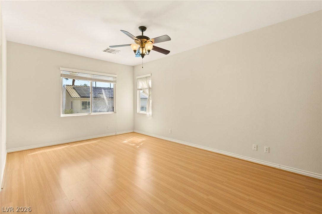 Smooth wood floors and dual windows maximize natural light throughout this versatile upper floor bedroom.