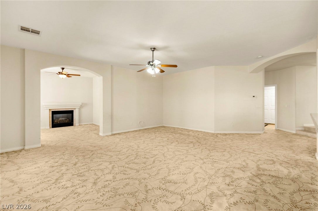 Patterned carpeting and arched doorways define this versatile open living space.