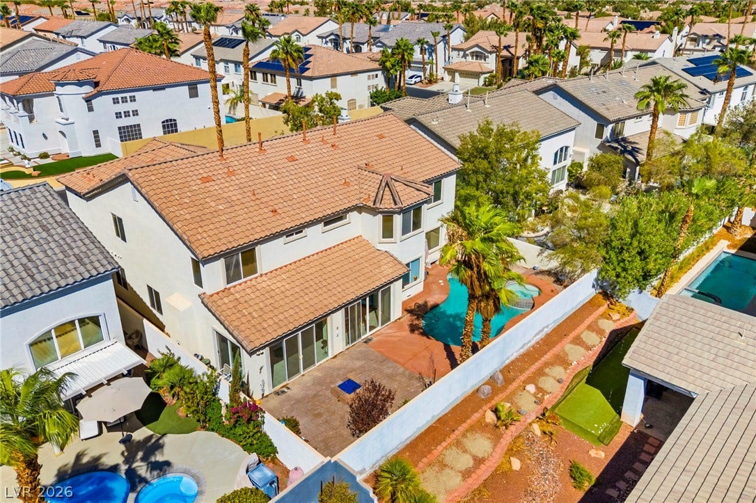 Mediterranean tile roof lines and backyard patio elements define this multi-level residential exterior.