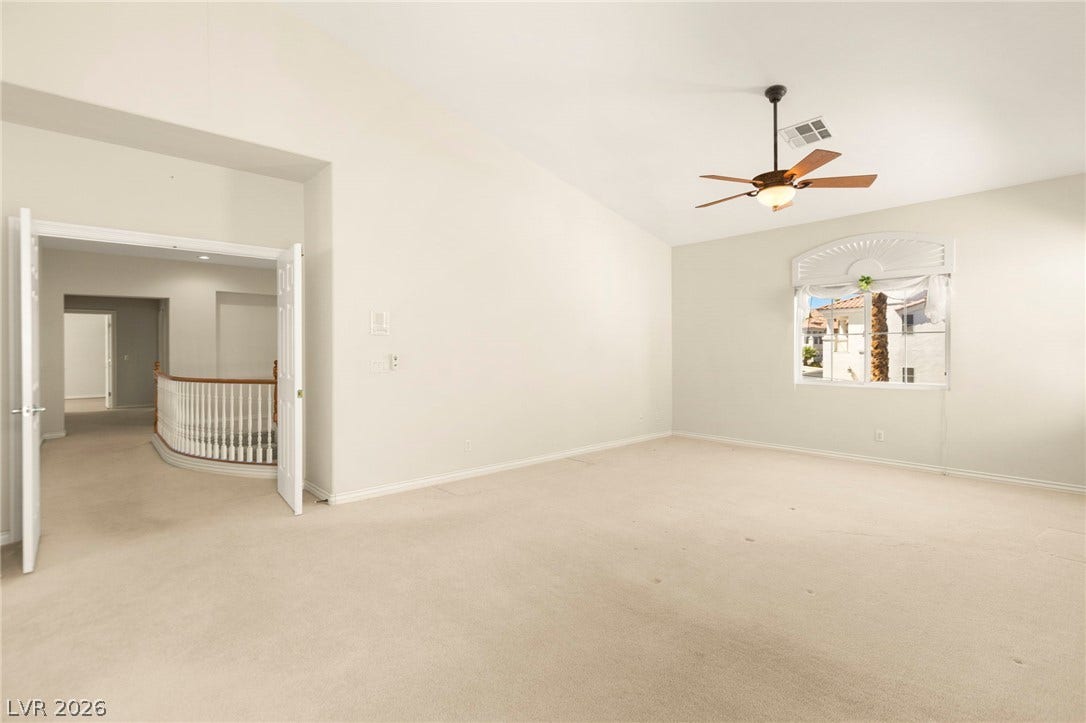 Vaulted ceilings and soft carpeting define this ultra-spacious primary bedroom.