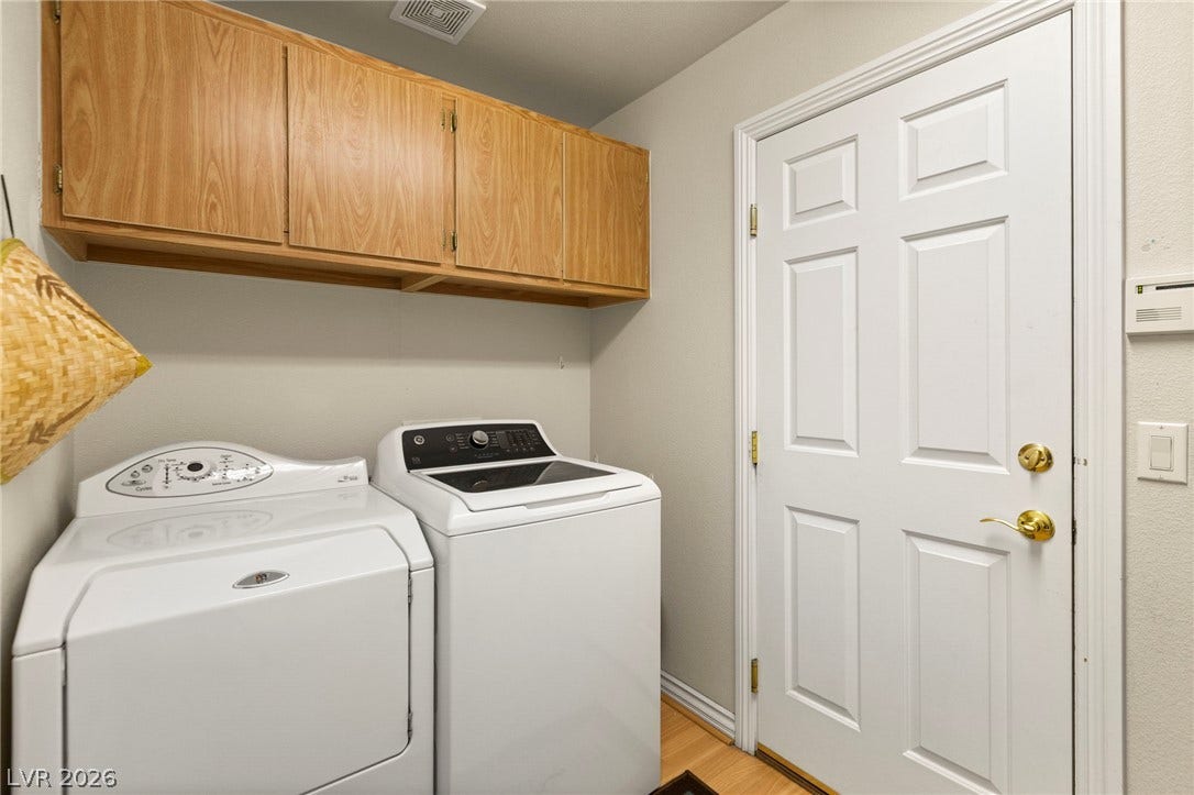 Ample wooden cabinetry brings efficient storage options to this dedicated laundry room.