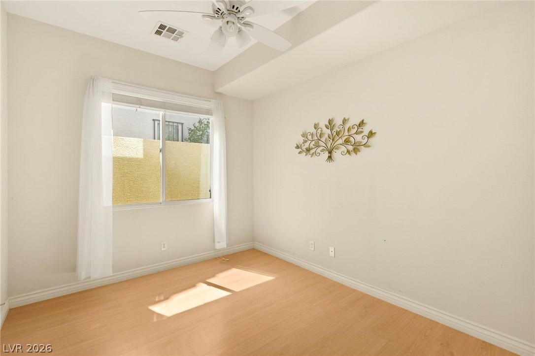 Additional main floor bedroom with natural lighting and wood flooring