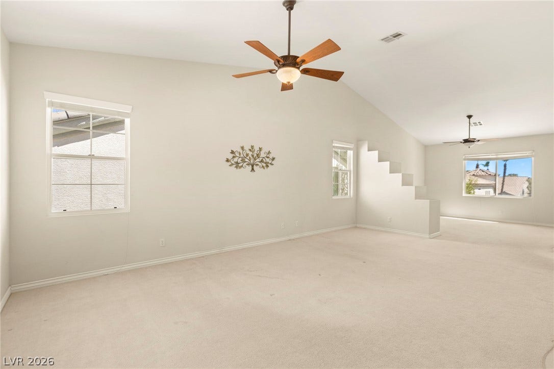 High vaulted ceilings and soft carpeting define this ultra-spacious primary with multi-level views.
