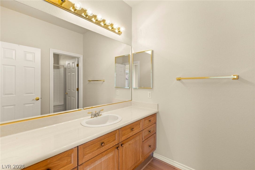 Warm wood cabinetry pairs with a generous vanity counter in this functional guest bathroom.
