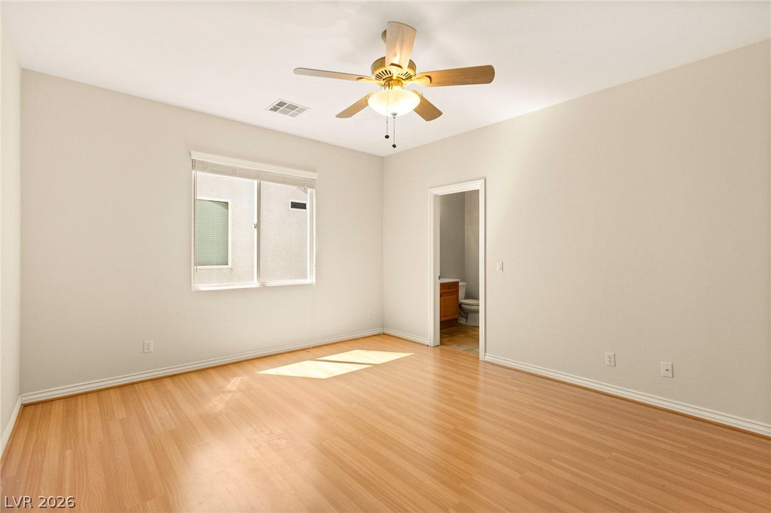 Gleaming hardwood floors and a wide window define this inviting bedroom space on the upper floor.