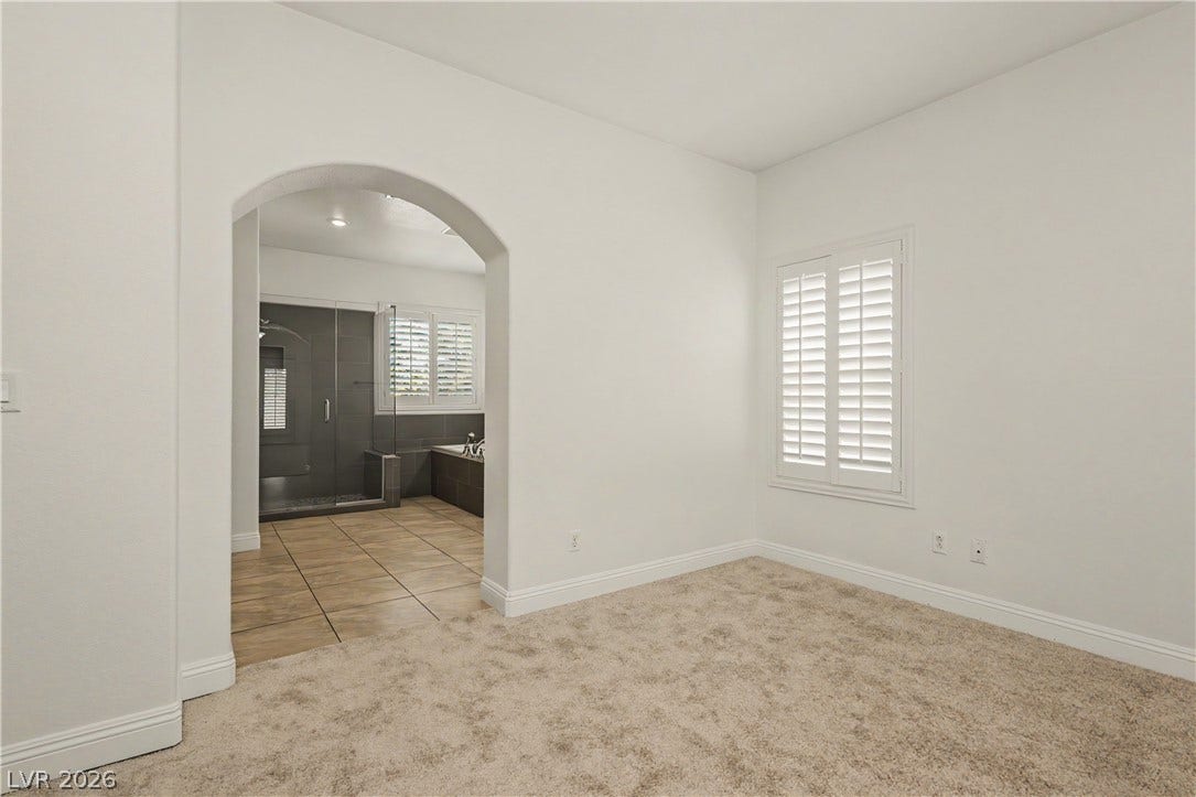 1424 Clipperton Avenue, Henderson, NV 89074 An arched doorway connects a carpeted room to an adjacent tiled bath.