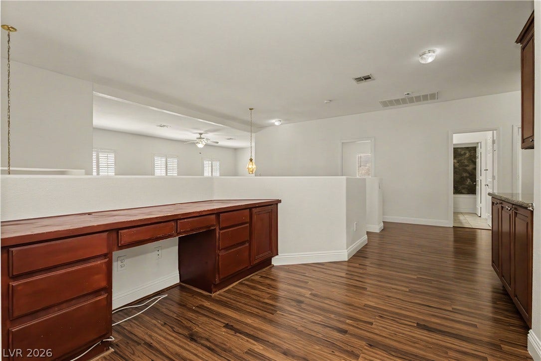 1424 Clipperton Avenue, Henderson, NV 89074 Rich wood-look flooring and custom built-in cabinetry define this versatile upper-level workspace.