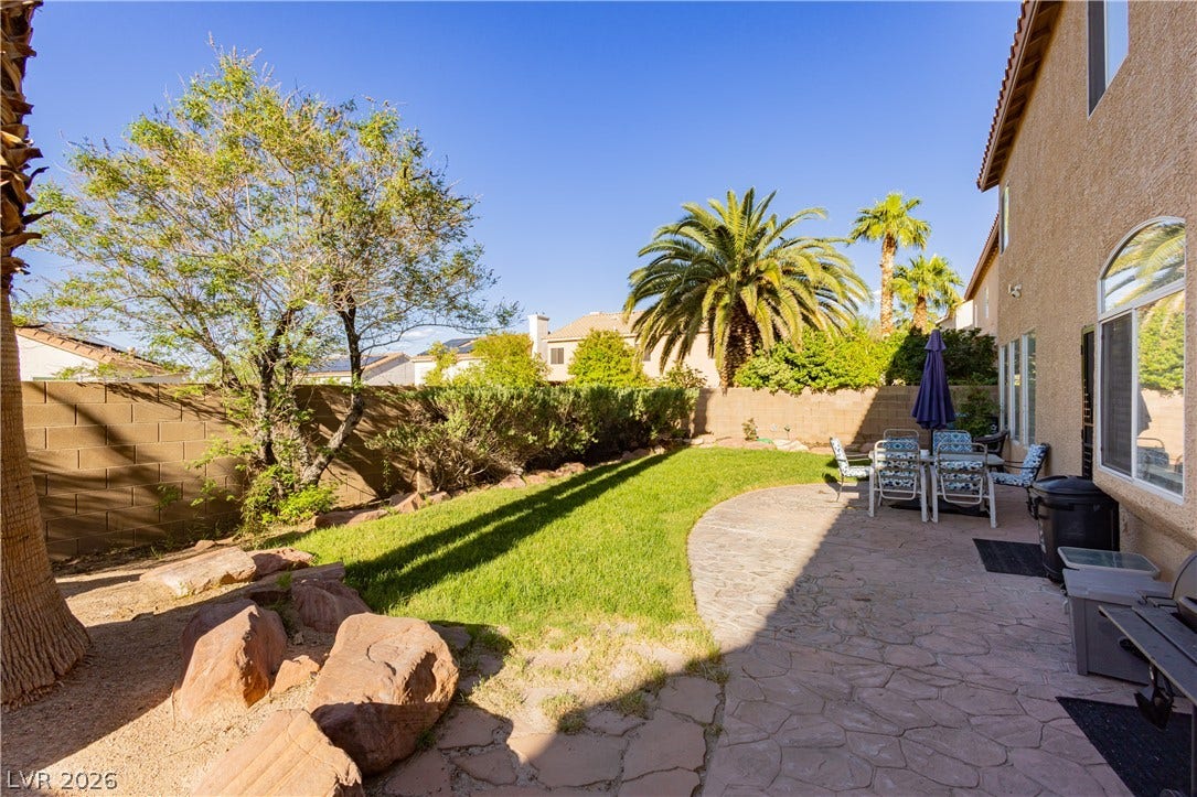 1424 Clipperton Avenue, Henderson, NV 89074 An inviting stone patio leads to a manicured lawn bordered by a block wall fence.