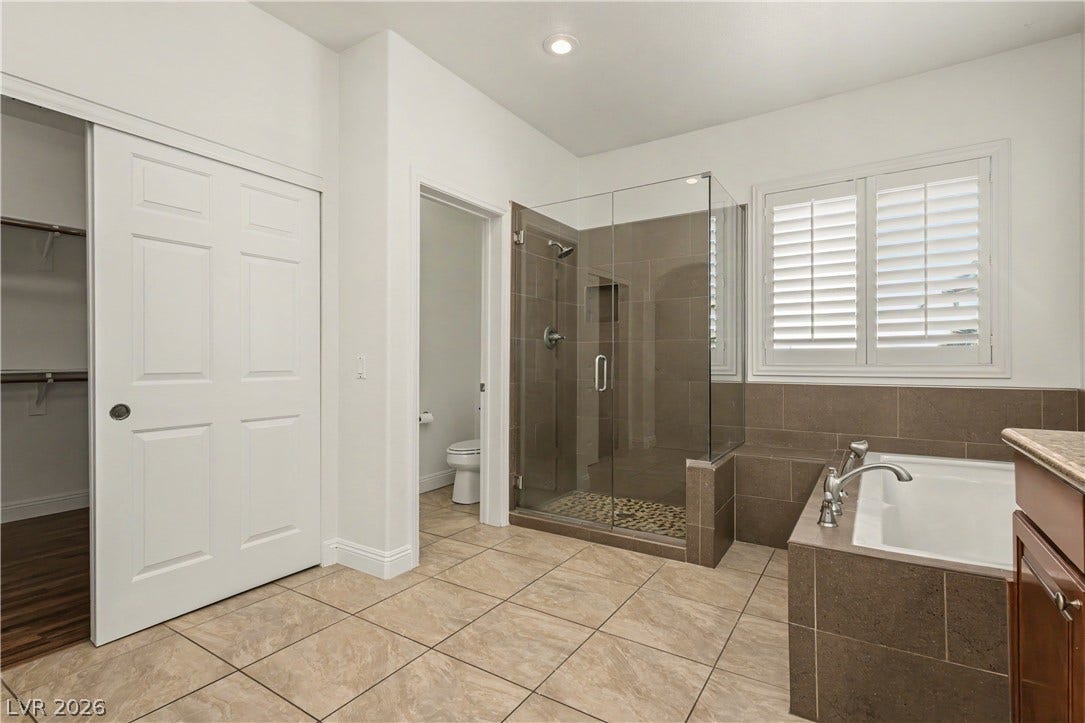 1424 Clipperton Avenue, Henderson, NV 89074 Tiled flooring and a glass-enclosed walk-in shower highlight this modern primary bathroom.