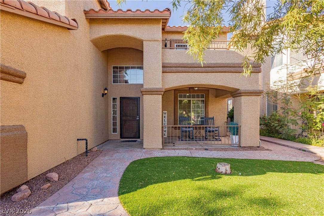 1424 Clipperton Avenue, Henderson, NV 89074 An inviting stone-paved walkway leads past green lawn to a covered front entry.