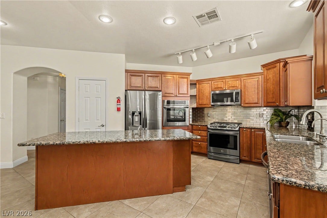 1424 Clipperton Avenue, Henderson, NV 89074 Rich wood cabinetry paired with granite countertops defines this functional cooking space.