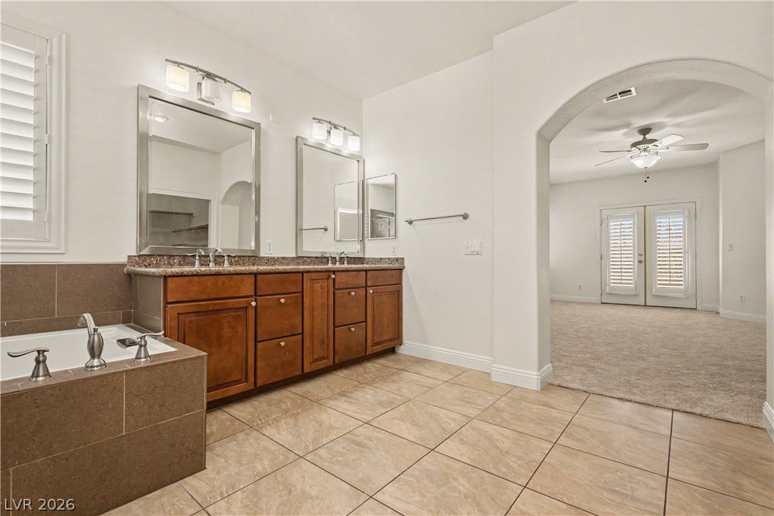 1424 Clipperton Avenue, Henderson, NV 89074 An arched doorway connects a tiled bath suite with a carpeted master bedroom.