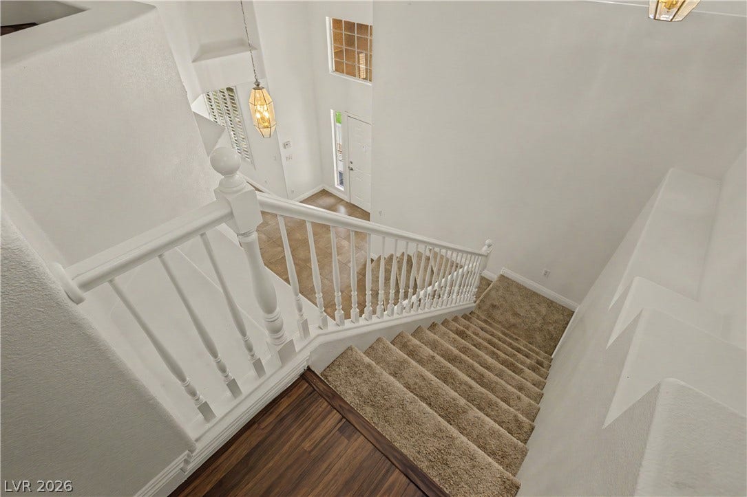 1424 Clipperton Avenue, Henderson, NV 89074 An open staircase looks down onto a tiled entrance foyer under towering high ceilings.