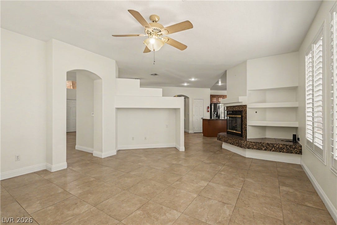 1424 Clipperton Avenue, Henderson, NV 89074 Tiled flooring and a fireplace with integrated shelving anchor this open living area.